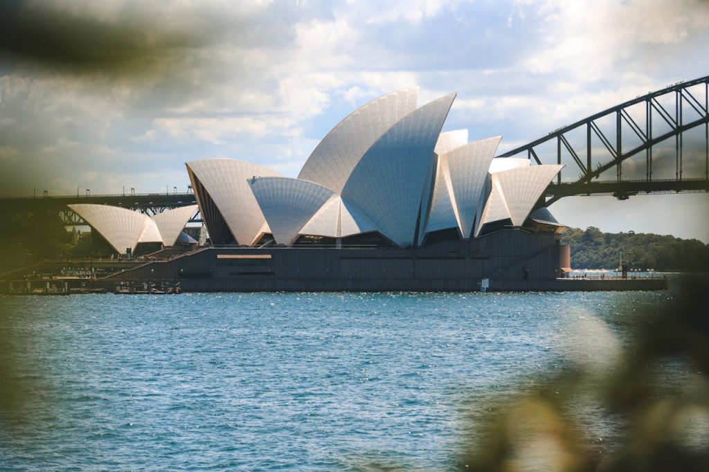 Iconic view of the Sydney Opera House and Sydney Harbor Bridge on a sunny day.