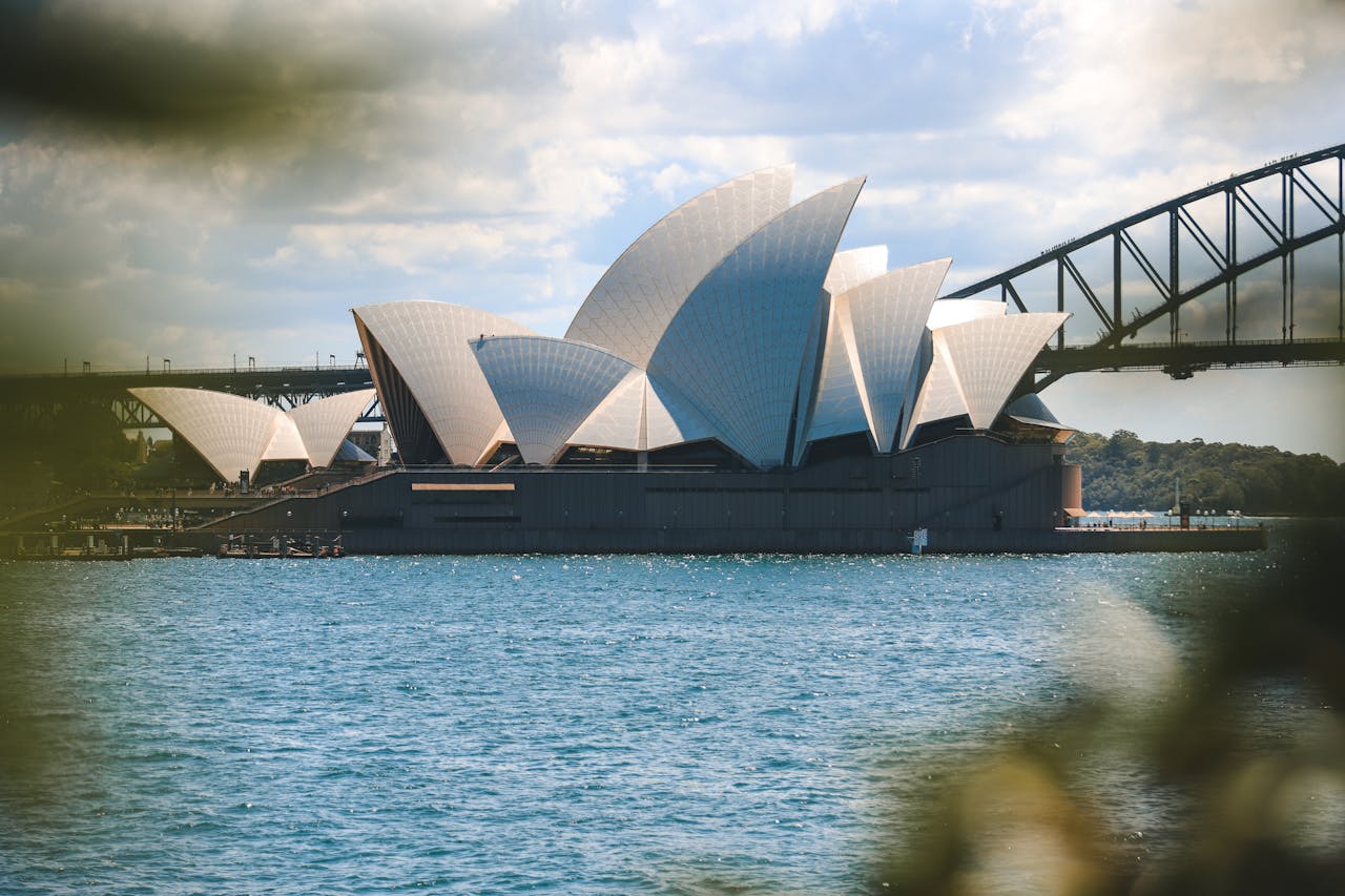 Iconic view of the Sydney Opera House and Sydney Harbor Bridge on a sunny day.